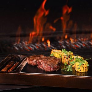 Grilled steak with corn and flames